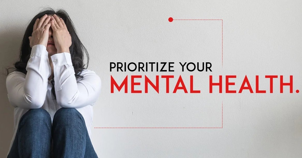 Person sitting peacefully outdoors, surrounded by nature, reflecting on their mental health and wellbeing