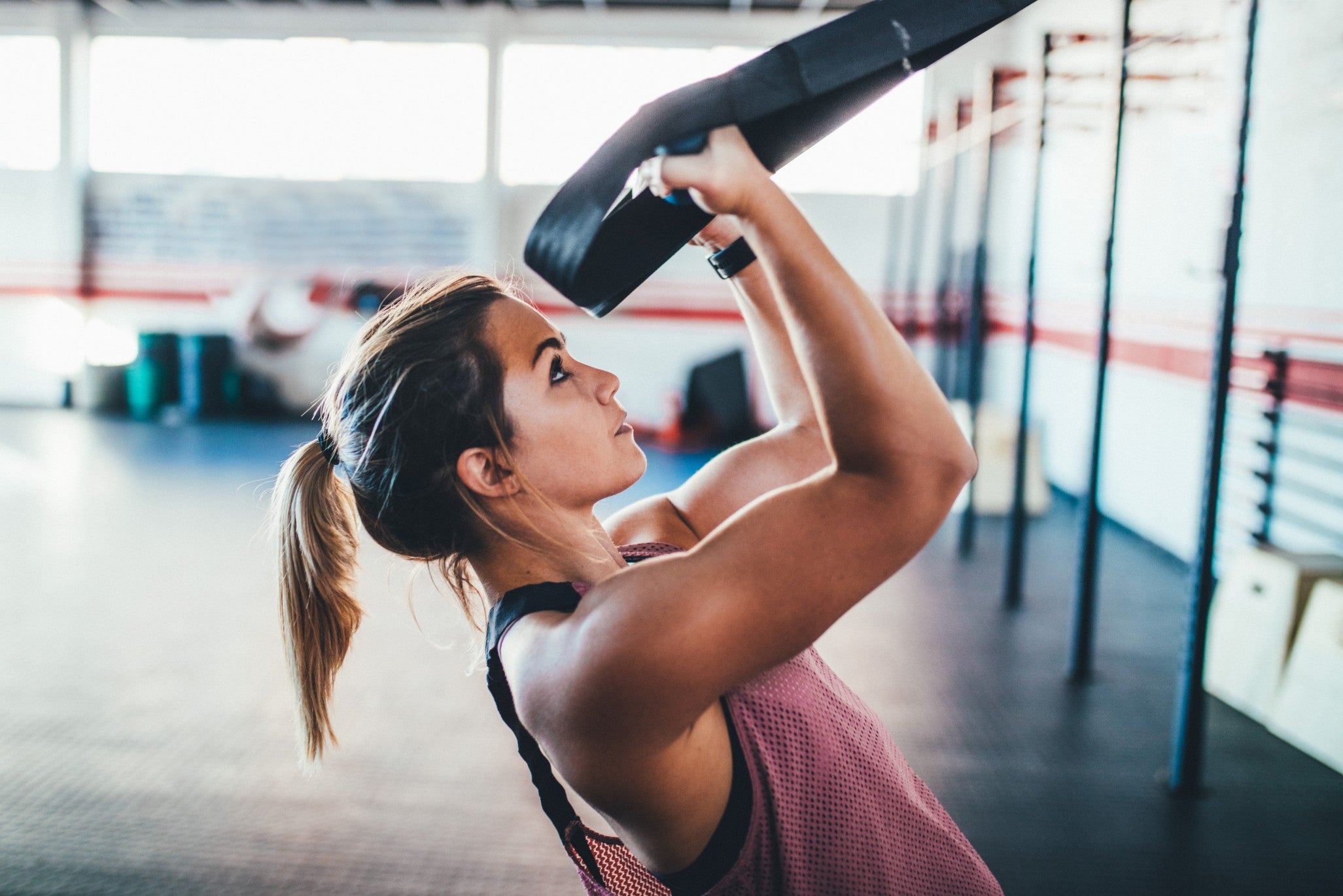 Woman engaging in an intense workout at the gym, showcasing strength and determination